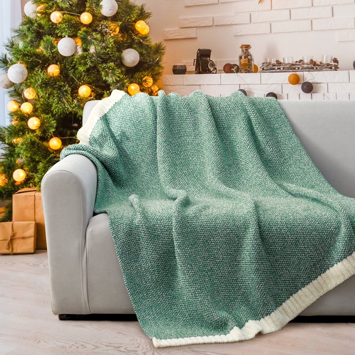 Heather Feather Yarn Throw Blanket in Heather Green draped over a sofa, adding a fresh and cozy touch to your space. #color_Heather Green