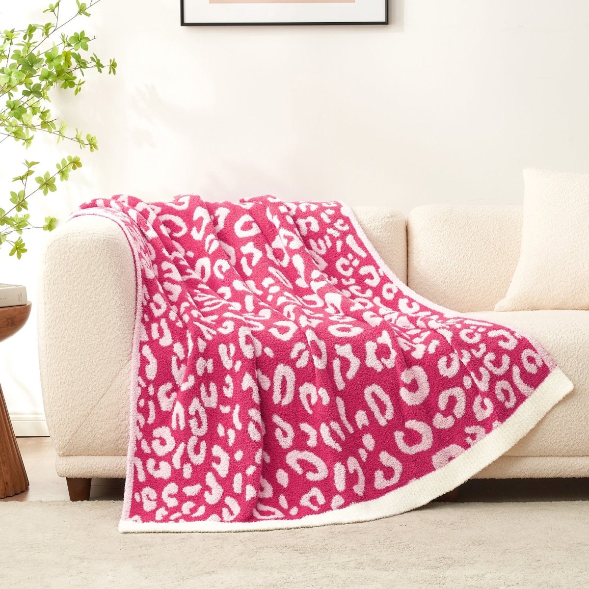 Reversible Leopard Feather Yarn Throw Blanket in Hot Pink draped over a sofa, highlighting its plush faux fur feel. #color_Hot Pink